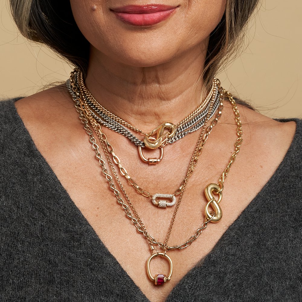 Gold chain with trundle lock ring attached against white backdrop