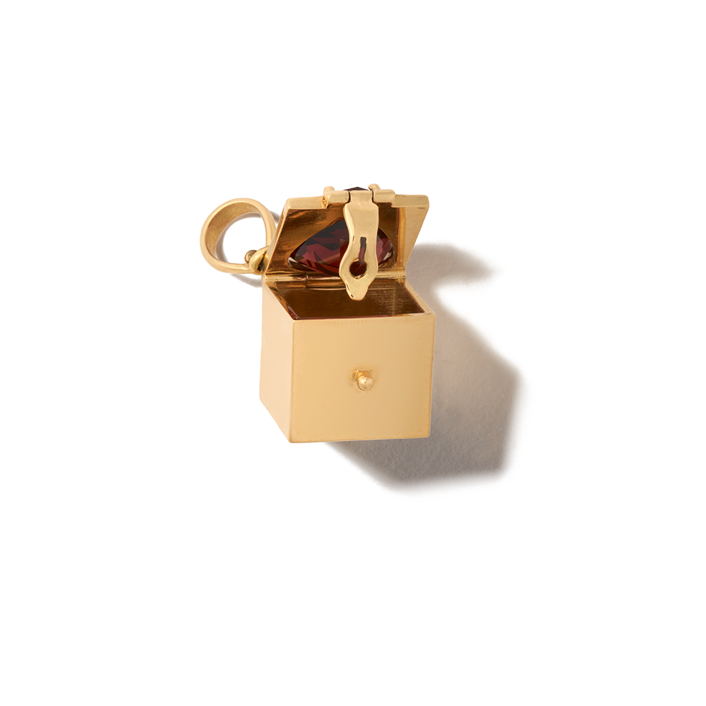 Angled front view of open gold garnet charm