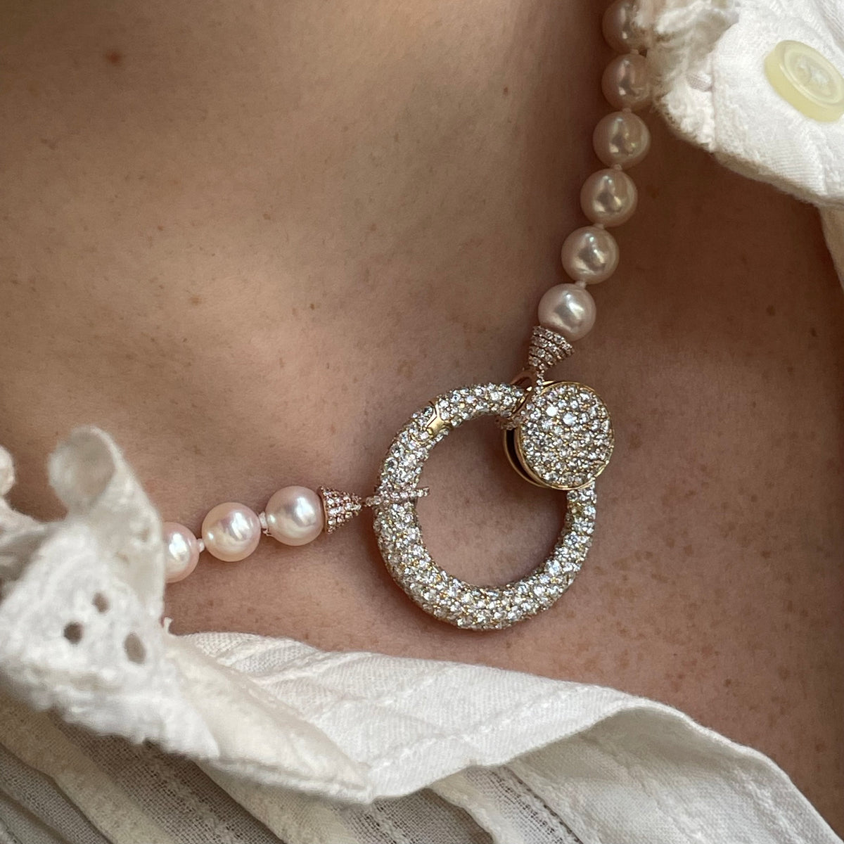 Close up of neck with necklace with diamond studded pendant charm