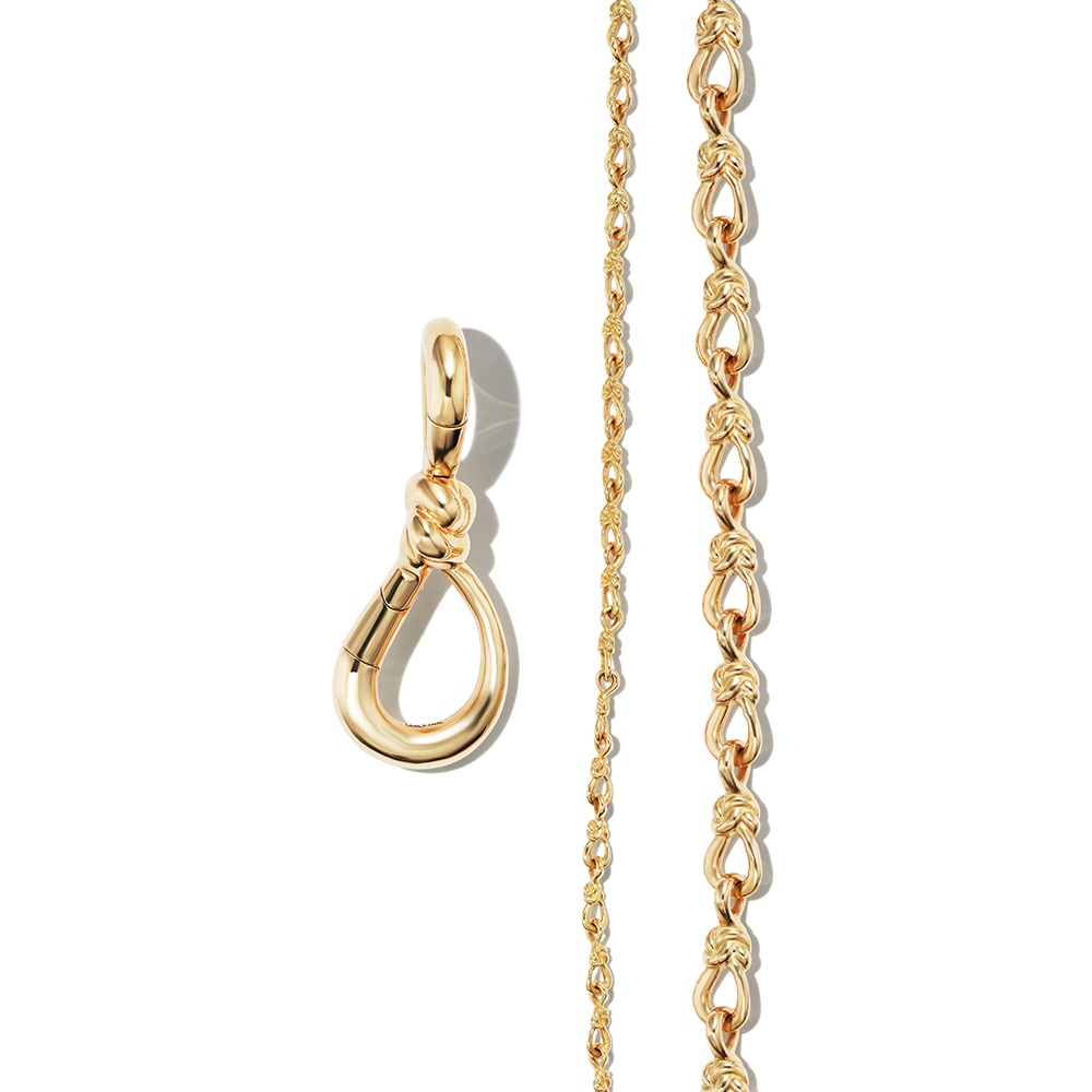 Gold knot charm alongside two lover's knot bracelet gold chains