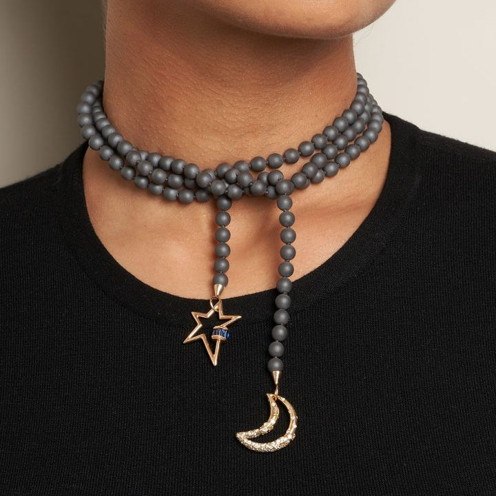 Woman wearing hematite bead necklace with moon and star charms