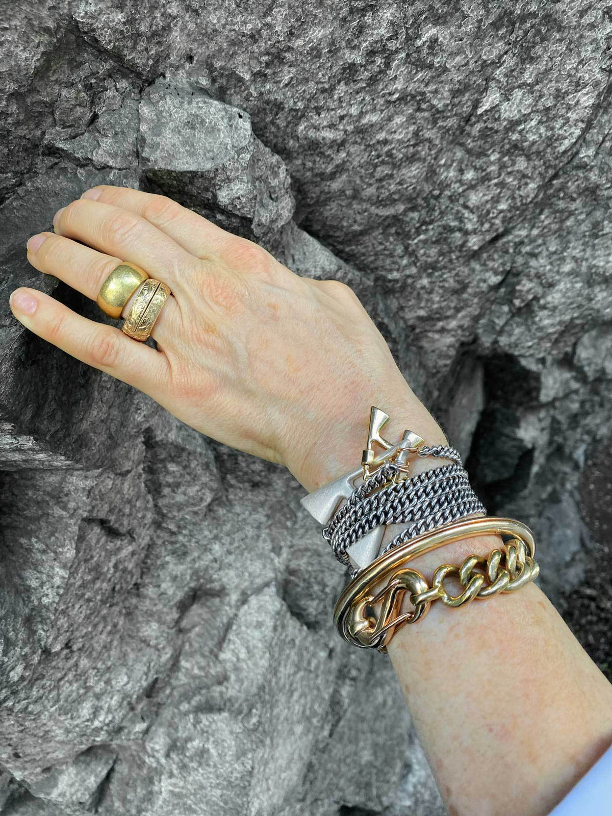 Wrist wearing multiple bracelets including bracelet with A lock